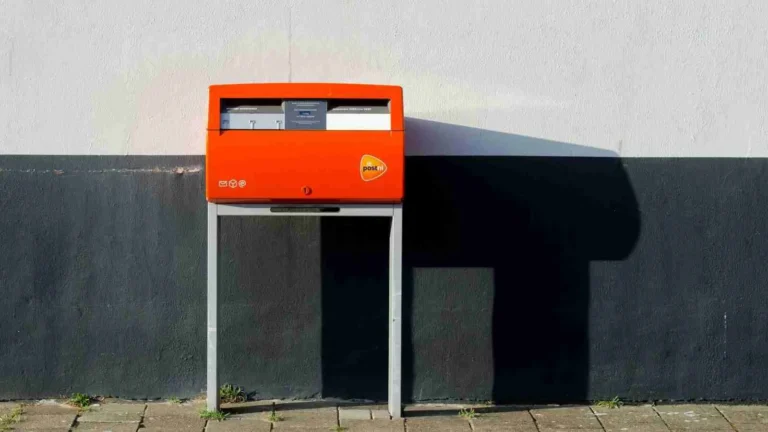 Een post nl brievenbus tegen een muur aan