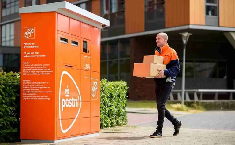 Een pakketbezorger die aan komt lopen bij een pakketautomaat van post nl